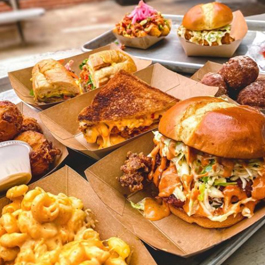 Several trays of mouthwatering Southern food, from BBQ sandwiches to mac n cheese and more