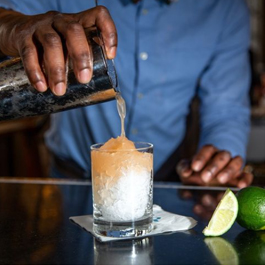 Close-up of man pouring a cocktail over ice