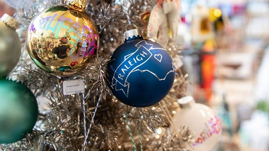 Close-up of a blue Raleigh holiday tree ball ornament