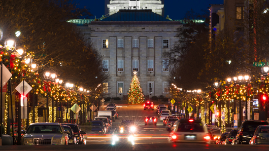 Looking down a festive Fayetteville St. towards the N.C. State Capitol with a massive holiday tree in front