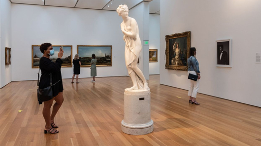 Woman taking a photo of a statue at North Carolina Museum of Art