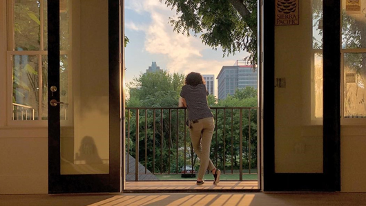 A hotel guest looking at the downtown Raleigh skyline from a balcony