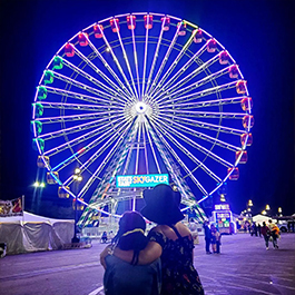Woman and daughter looking at a huge Ferris Wheel