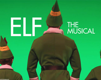 A promotional image for "Elf: The Musical" featuring a green background and Buddy the elf towering over two of his peers on either side of him