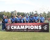 A team of cricket players wearing blue uniforms lined up together holding banner that says "champions" while confetti is in the air, celebrating the 2021 championship win