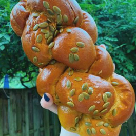 A large loaf of bread covered in pumpkin seeds