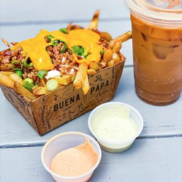Close-up photo of loaded fries and an iced coffee