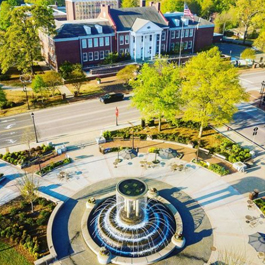 Drone shot of downtown Cary, including a giant Downtown Park water fountain and the front of the Cary Arts Center
