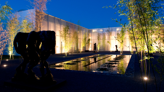 Rodin garden at the North Carolina Museum of Art at night, light reflecting off of the reflection pond