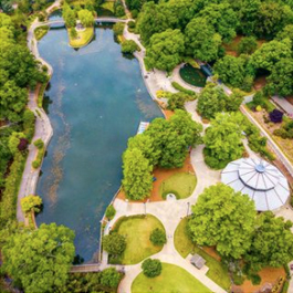 Aerial photo of Pullen Park, with a big pond and a view of the top of the historic carousel