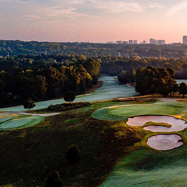 Aerial shot of beautiful, rolling hills at Lonnie Poole Golf Course, with the downtown Raleigh skyline in the background 