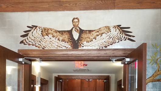 Artwork over a door of a man with bird wings