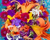 An up close look at a very full and colorful bouquet of flowers, colors are primarily orange, yellow and purple 