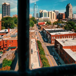 View of the downtown Raleigh skyline from a window with the pane in the foreground
