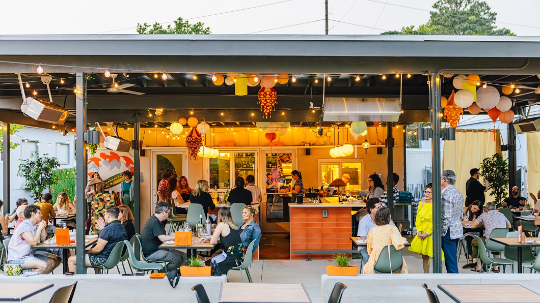 A dusk gathering of people on the eclectic patio of chef Cheetie Kumar's new restaurant Ajja.