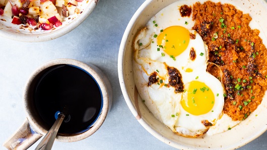 A top-down view of a brunch that includes coffee, Cajun-style grits and eggs