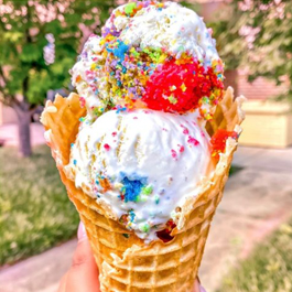 A huge ice cream cone with rainbow-colored toppings