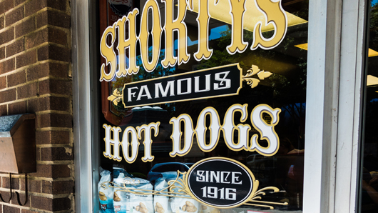 Front door signage at Shorty's Famous Hot Dogs has old-fashioned lettering and reads 'Since 1916'