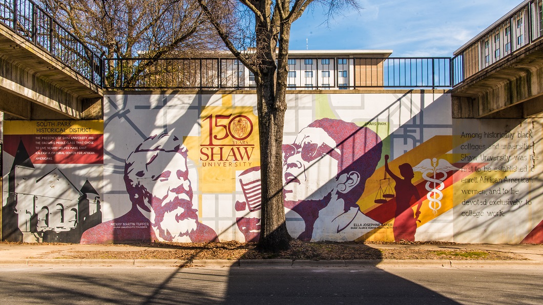 Photo looking straight on at a mural that celebrates Shaw University's 150th Anniversary, using red and yellow tones, featuring Ella Baker, a civil rights activist that graduated from Shaw in 1927.