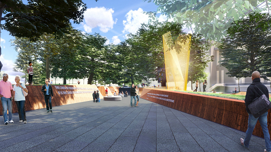 Rendering of Freedom Park, with a wide sidewalk and a large, golden piece of outdoor art next to a long, brick wall