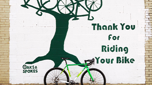 Outdoor mural of a three with bikes as its branches and that says Thank You for Riding Your Bike