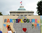 Mural in front of the N.C. State Capitol that says #Artsplosure
