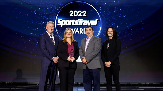 A photo of Dennis Edwards, Tori Collins, Jason Philbeck and Jocelyn O'Sullivan standing in business attire on a stage with an award