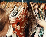 A person perusing a rack of vintage clothing