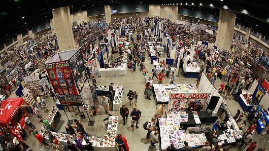 Fisheye, top-down view of crowd at a convention inside the Raleigh Convention Center, with large booths setup for attendees to view merchandise and other products